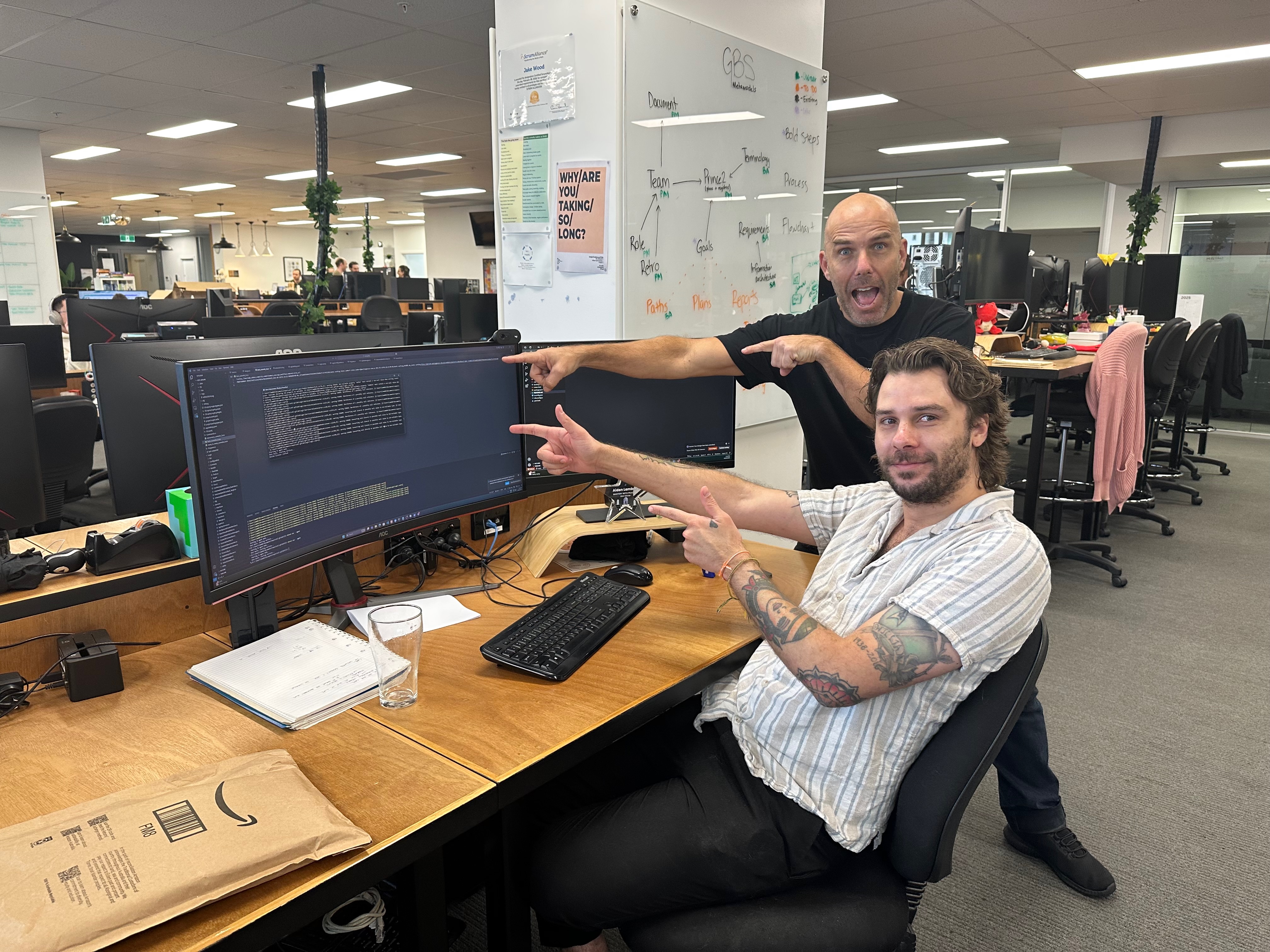 Eban with a team in an office pointing at a development screen.